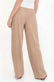 Pantalón de fit recto, cintura media con pretina y trabillas, pinzas frontales con raya, bolsillos delanteros y vivos decorativos posteriores. Cierre frontal con broche y cremallera ocultos.