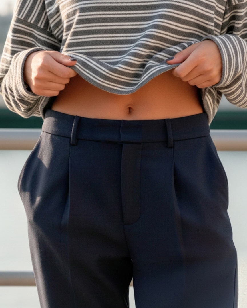 Pantalón de fit recto, pinzas frontales, cintura alta con pretina y trabillas, bolsillos delanteros, cierre frontal con broche y cremallera ocultos.