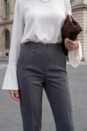 Pantalón de fit recto, cintura alta con pinzas, vivos decorativos frontales, detalle posterior en v, raya frontal y posterior. Cierre frontal con cremallera oculta.