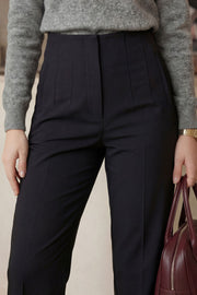 Pantalón de fit recto, cintura alta con pinzas, vivos decorativos frontales, detalle posterior en v, raya frontal y posterior. Cierre frontal con cremallera oculta.