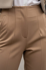 Pantalón de fit recto, cintura alta con pinzas, vivos decorativos frontales, detalle posterior en v, raya frontal y posterior. Cierre frontal con cremallera oculta.