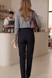 Pantalón de fit recto, cintura alta con pinzas, vivos decorativos frontales, detalle posterior en v, raya frontal y posterior. Cierre frontal con cremallera oculta.