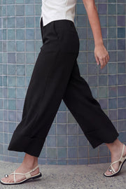 Pantalón cropped de fit recto, cintura media con pretina y trabillas, bolsillos delanteros y posteriores de parche. Detalle de raya frontal y posterior, doblez en bajo, cierre frontal con broche y cremallera oculta.