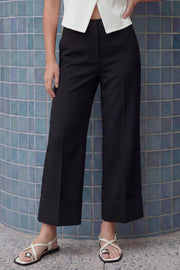 Pantalón cropped de fit recto, cintura media con pretina y trabillas, bolsillos delanteros y posteriores de parche. Detalle de raya frontal y posterior, doblez en bajo, cierre frontal con broche y cremallera oculta.