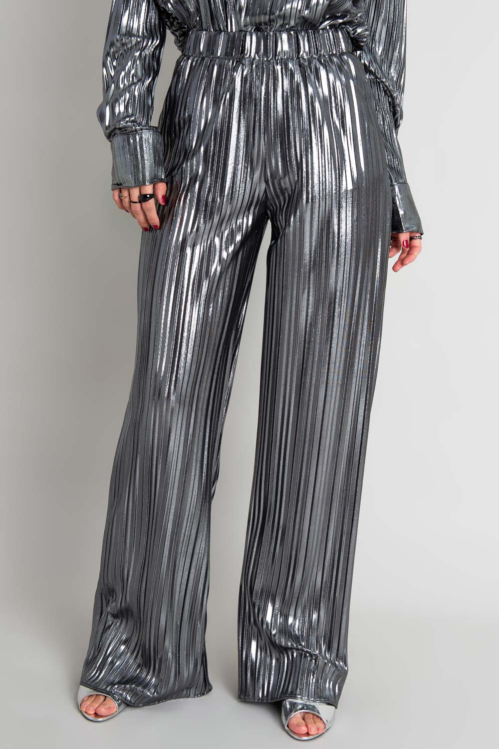 Pantalón satinado de fit wide leg, plisados en tejido y cintura alta con pretina elástica.