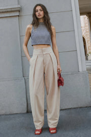 Pantalón fit balloon, de cintura alta con pretina ancha, bolsillos delanteros, pinzas frontales con detalle decorativo, cierre frontal con broche y cremallera ocultos.