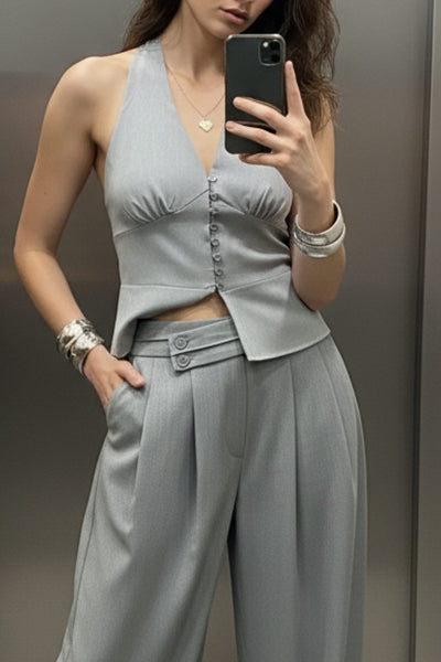 Pantalón de fit wide leg, cintura alta con pretina criss cross y detalle decorativo, pinzas frontales, bolsillos delanteros, cierre frontal con botones y cremallera oculta.