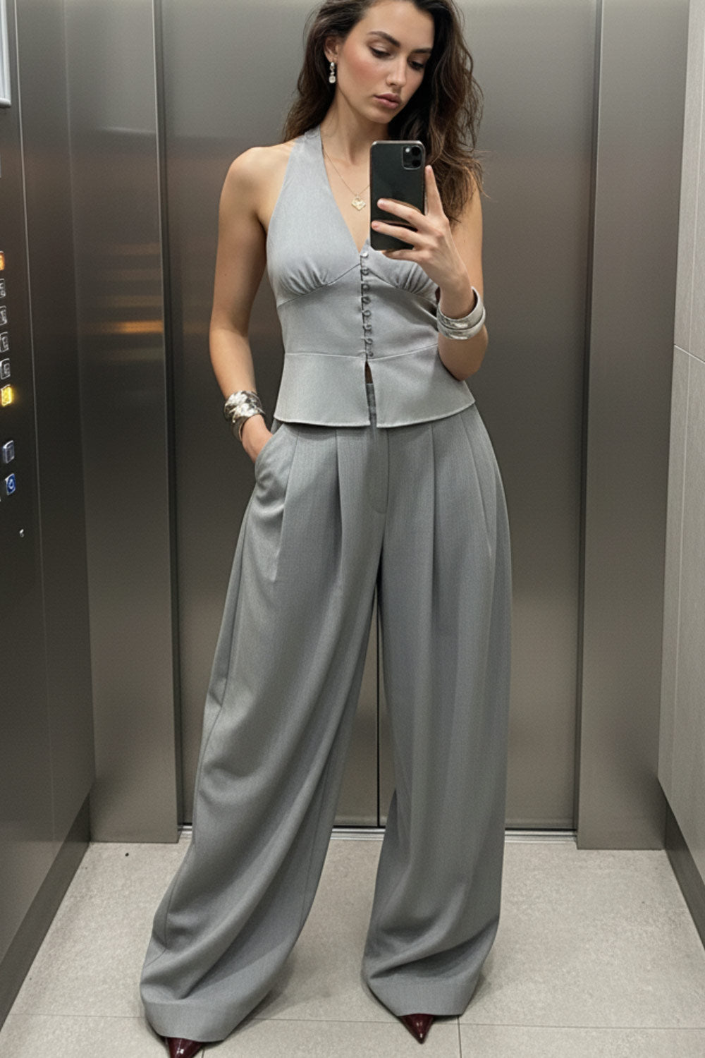 Pantalón de fit wide leg, cintura alta con pretina criss cross y detalle decorativo, pinzas frontales, bolsillos delanteros, cierre frontal con botones y cremallera oculta.