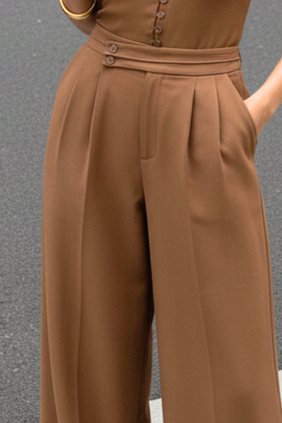 Pantalón de fit wide leg, cintura alta con pretina criss cross y detalle decorativo, pinzas frontales, bolsillos delanteros, cierre frontal con botones y cremallera oculta.