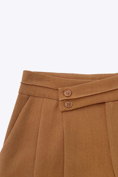 Pantalón de fit wide leg, cintura alta con pretina criss cross y detalle decorativo, pinzas frontales, bolsillos delanteros, cierre frontal con botones y cremallera oculta.