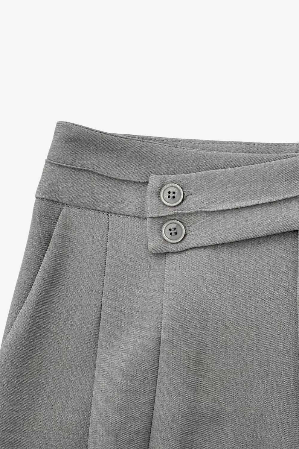 Pantalón de fit wide leg, cintura alta con pretina criss cross y detalle decorativo, pinzas frontales, bolsillos delanteros, cierre frontal con botones y cremallera oculta.