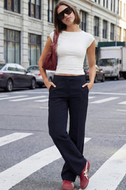 Pantalón ajustado de fit flare, cintura media con pretina, bolsillos delanteros y vivos decorativos posteriores. Cierre frontal con broche y cremallera ocultos.