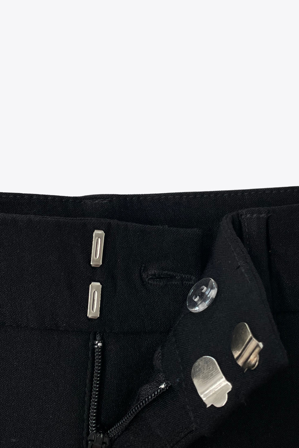 Pantalón ajustado de fit flare, cintura alta con pretina y trabillas, bolsillos delanteros y vivos decorativos posteriores. 