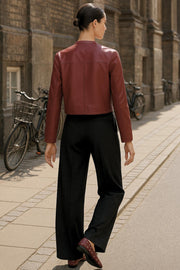 Pantalón de fit wide leg, cintura alta con pretina y trabillas, pinzas frontales, bolsillos delanteros y vivos decorativos posteriores. Cierre frontal con botón y cremallera oculta.