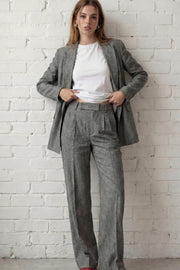 Pantalón de fit wide leg, cintura alta con pretina elástica posterior y trabillas, pinzas frontales, bolsillos delanteros y vivo decorativo posterior. Detalle de raya frontal, cierre con broche y cremallera ocultos.