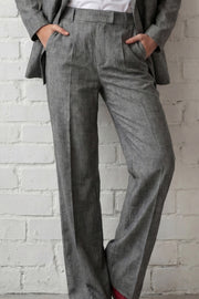 Pantalón de fit wide leg, cintura alta con pretina elástica posterior y trabillas, pinzas frontales, bolsillos delanteros y vivo decorativo posterior. Detalle de raya frontal, cierre con broche y cremallera ocultos.