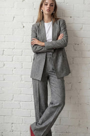 Pantalón de fit wide leg, cintura alta con pretina elástica posterior y trabillas, pinzas frontales, bolsillos delanteros y vivo decorativo posterior. Detalle de raya frontal, cierre con broche y cremallera ocultos.