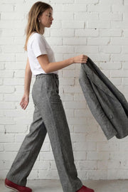 Pantalón de fit wide leg, cintura alta con pretina elástica posterior y trabillas, pinzas frontales, bolsillos delanteros y vivo decorativo posterior. Detalle de raya frontal, cierre con broche y cremallera ocultos.