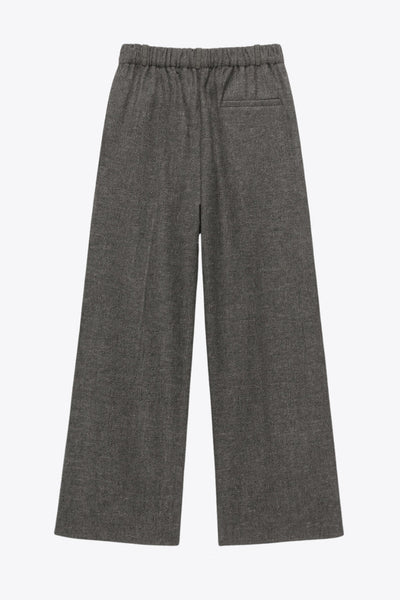 Pantalón de fit wide leg, cintura alta con pretina elástica posterior y trabillas, pinzas frontales, bolsillos delanteros y vivo decorativo posterior. Detalle de raya frontal, cierre con broche y cremallera ocultos.