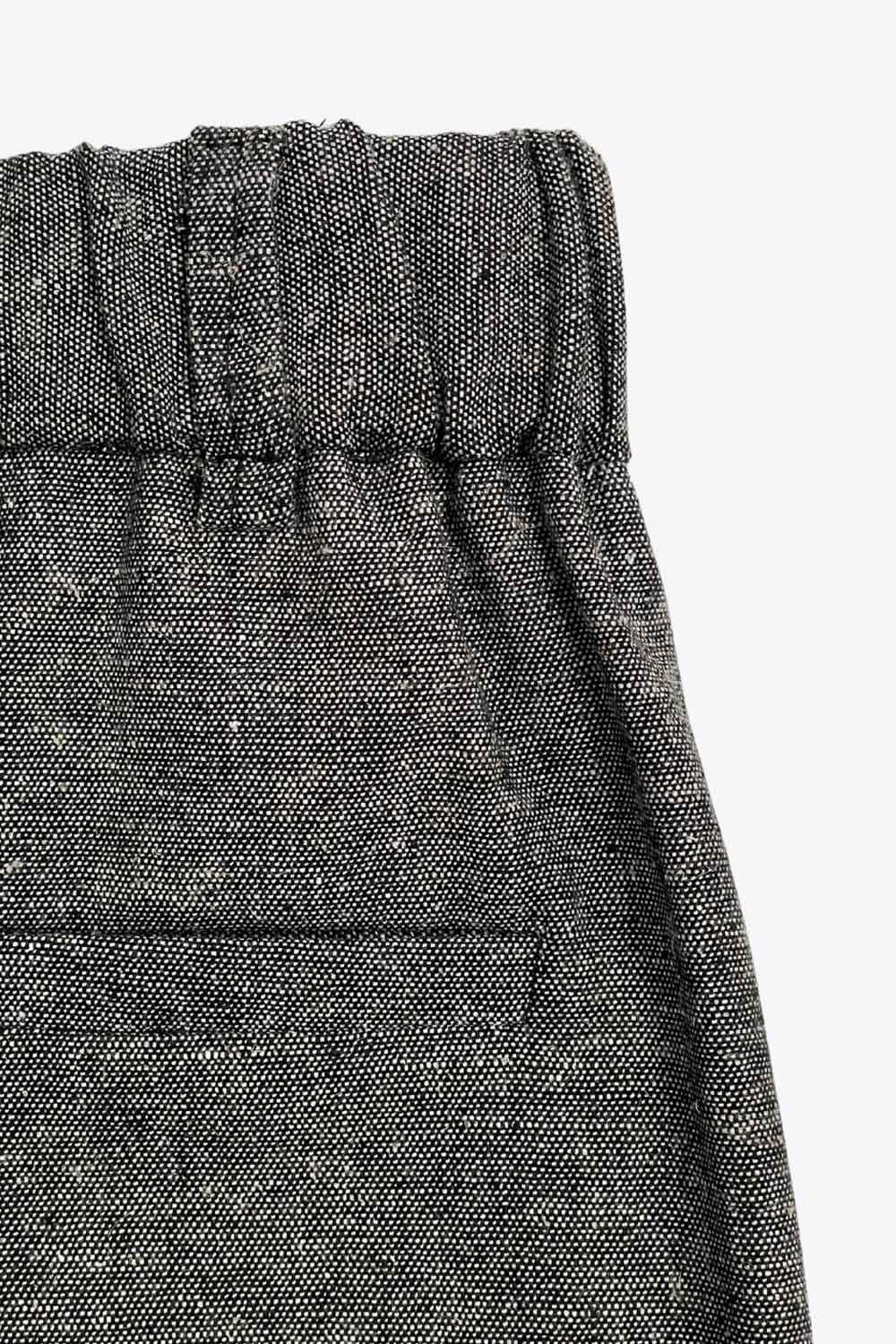 Pantalón de fit wide leg, cintura alta con pretina elástica posterior y trabillas, pinzas frontales, bolsillos delanteros y vivo decorativo posterior. Detalle de raya frontal, cierre con broche y cremallera ocultos.