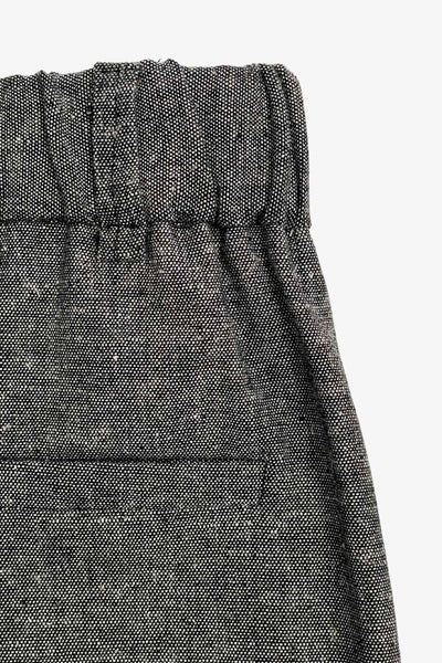 Pantalón de fit wide leg, cintura alta con pretina elástica posterior y trabillas, pinzas frontales, bolsillos delanteros y vivo decorativo posterior. Detalle de raya frontal, cierre con broche y cremallera ocultos.