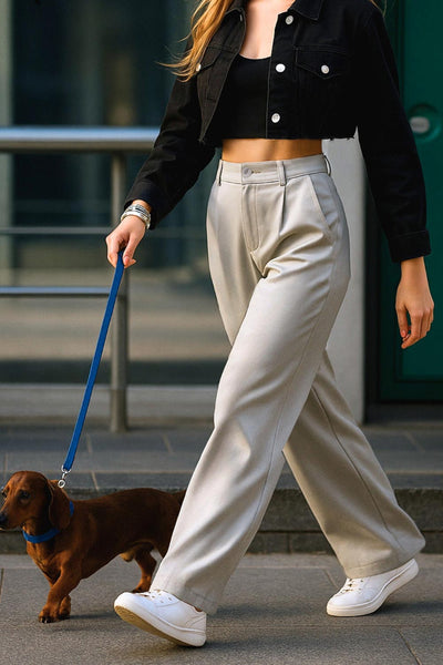 Pantalón de fit wide leg, cintura alta con pretina elástica posterior y trabillas, pinzas frontales y bolsillos delanteros. Cierre frontal con botón y cremallera ocultos.