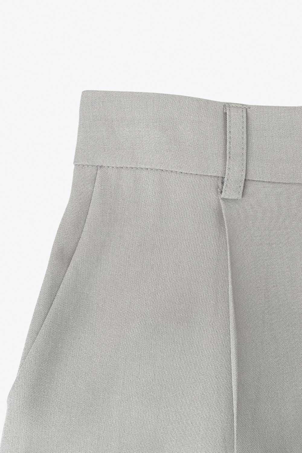 Pantalón de fit wide leg, cintura alta con pretina elástica posterior y trabillas, pinzas frontales y bolsillos delanteros. Cierre frontal con botón y cremallera ocultos.