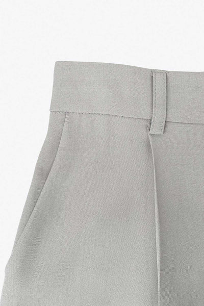 Pantalón de fit wide leg, cintura alta con pretina elástica posterior y trabillas, pinzas frontales y bolsillos delanteros. Cierre frontal con botón y cremallera ocultos.