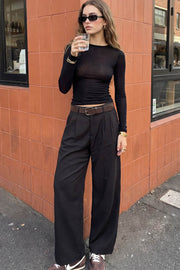 Pantalón de fit wide leg, cintura alta con pretina y trabillas, pinzas frontales, bolsillos delanteros y vivo decorativo posterior. Cierre con botón y cremallera oculta.