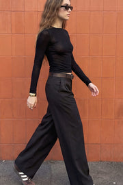 Pantalón de fit wide leg, cintura alta con pretina y trabillas, pinzas frontales, bolsillos delanteros y vivo decorativo posterior. Cierre con botón y cremallera oculta.