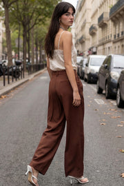 Pantalón de fit wide leg, cintura alta con pretina y trabillas, pinzas frontales, bolsillos delanteros y vivo decorativo posterior. Cierre con botón y cremallera oculta.