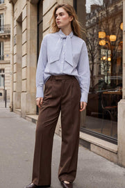 Pantalón de fit wide leg, cintura alta con pretina elástica posterior y trabillas, pinzas frontales, bolsillos delanteros y vivo decorativo posterior. Cierre frontal con broche y cremallera ocultos. Detalle de raya frontal y posterior.