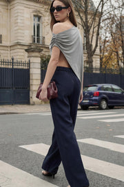 Pantalón de fit wide leg, cintura alta con pretina elástica posterior y trabillas, pinzas frontales, bolsillos delanteros y vivo decorativo posterior. Cierre frontal con broche y cremallera ocultos. Detalle de raya frontal y posterior.
