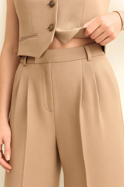 Pantalón de fit wide leg, cintura alta con pretina elástica posterior y trabillas, pinzas frontales, bolsillos delanteros y vivo decorativo posterior. Cierre frontal con broche y cremallera ocultos. Detalle de raya frontal y posterior.