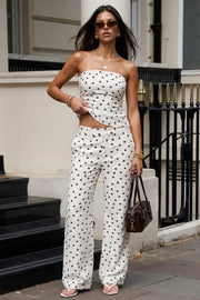 Pantalón de fit recto, estampado polka dot, cintura alta con pretina elástica posterior y trabillas, bolsillos delanteros, cierre frontal con broche y cremallera oculta.