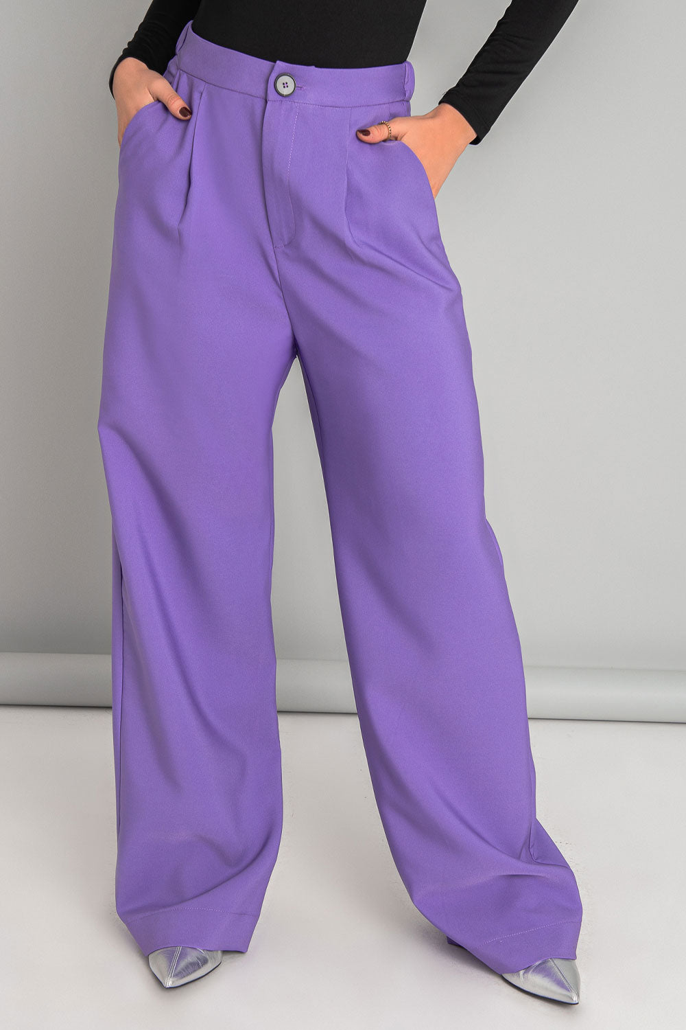 Pantalón de fit wide leg, pinzas frontales, bolsillos delanteros, cintura alta con pretina elástica posterior, cierre frontal con cremallera oculta y botón en contraste.