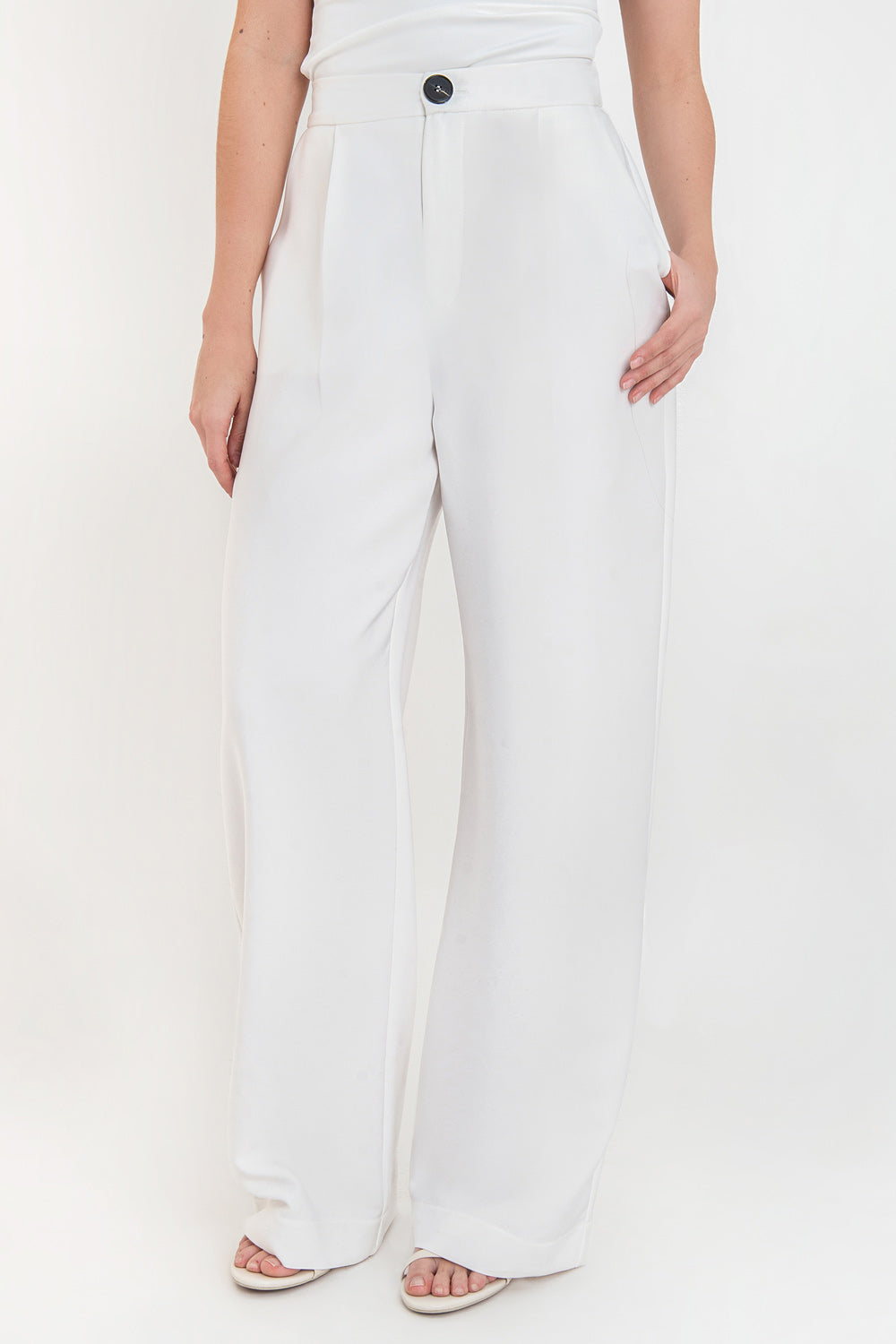 Pantalón de fit wide leg, pinzas frontales, bolsillos delanteros, cintura alta con pretina elástica posterior, cierre frontal con cremallera oculta y botón en contraste.