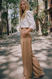 Pantalón de fit wide leg, cintura media con pretina, trabillas ajustables laterales, pinzas frontales, bolsillos delanteros y vivos decorativos posteriores. Cierre frontal con broche y cremallera ocultos.