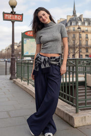 Pantalón de fit wide leg, cintura media con pretina, trabillas ajustables laterales, pinzas frontales, bolsillos delanteros y vivos decorativos posteriores. Cierre frontal con broche y cremallera ocultos.