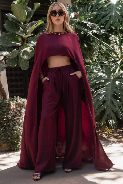 Pantalón de fit wide leg, cintura alta con pretina, trabillas y lazo amarrable en cintura, pinzas frontales y bolsillos delanteros. Cierre frontal con broche y cremallera oculta.