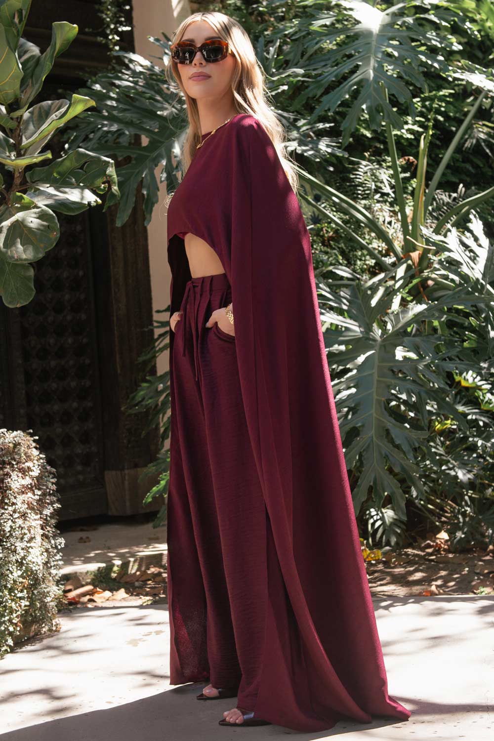 Pantalón de fit wide leg, cintura alta con pretina, trabillas y lazo amarrable en cintura, pinzas frontales y bolsillos delanteros. Cierre frontal con broche y cremallera oculta.