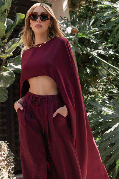 Pantalón de fit wide leg, cintura alta con pretina, trabillas y lazo amarrable en cintura, pinzas frontales y bolsillos delanteros. Cierre frontal con broche y cremallera oculta.