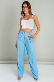 Pantalón de fit wide leg, pinzas frontales, bolsillos delanteros, cintura alta con pretina y trabillas. Cierre frontal con cremallera oculta y botón lateral en contraste.