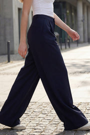 Pantalón de fit wide leg, cintura alta con pretina, pinzas frontales, bolsillos delanteros y vivos decorativos posteriores. Cierre frontal con broche y cremallera ocultos. Detalle v en pretina posterior.