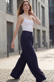 Pantalón de fit wide leg, cintura alta con pretina, pinzas frontales, bolsillos delanteros y vivos decorativos posteriores. Cierre frontal con broche y cremallera ocultos. Detalle v en pretina posterior.