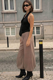 Pantalón de fit wide leg, cintura alta con pretina, pinzas frontales, bolsillos delanteros y vivos decorativos posteriores. Cierre frontal con broche y cremallera ocultos. Detalle v en pretina posterior.