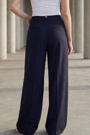 Pantalón de fit wide leg, cintura alta con pretina, pinzas frontales, bolsillos delanteros y vivos decorativos posteriores. Cierre frontal con broche y cremallera ocultos. Detalle v en pretina posterior.