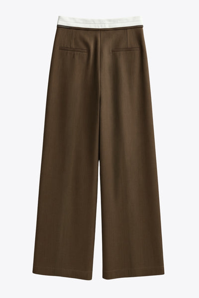 Pantalón de fit wide leg, pinzas frontales, cintura media, pretina con detalle de tailoring en contraste, bolsillos delanteros y vivos decorativos posteriores. Cierre frontal con broche y cremallera ocultos.