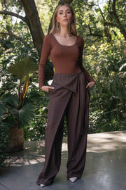 Pantalón de estampado rayas, fit wide leg, pinzas frontales, cintura alta y cruce frontal con lazo amarrable lateral. Detalle decorativo en pretina frontal.