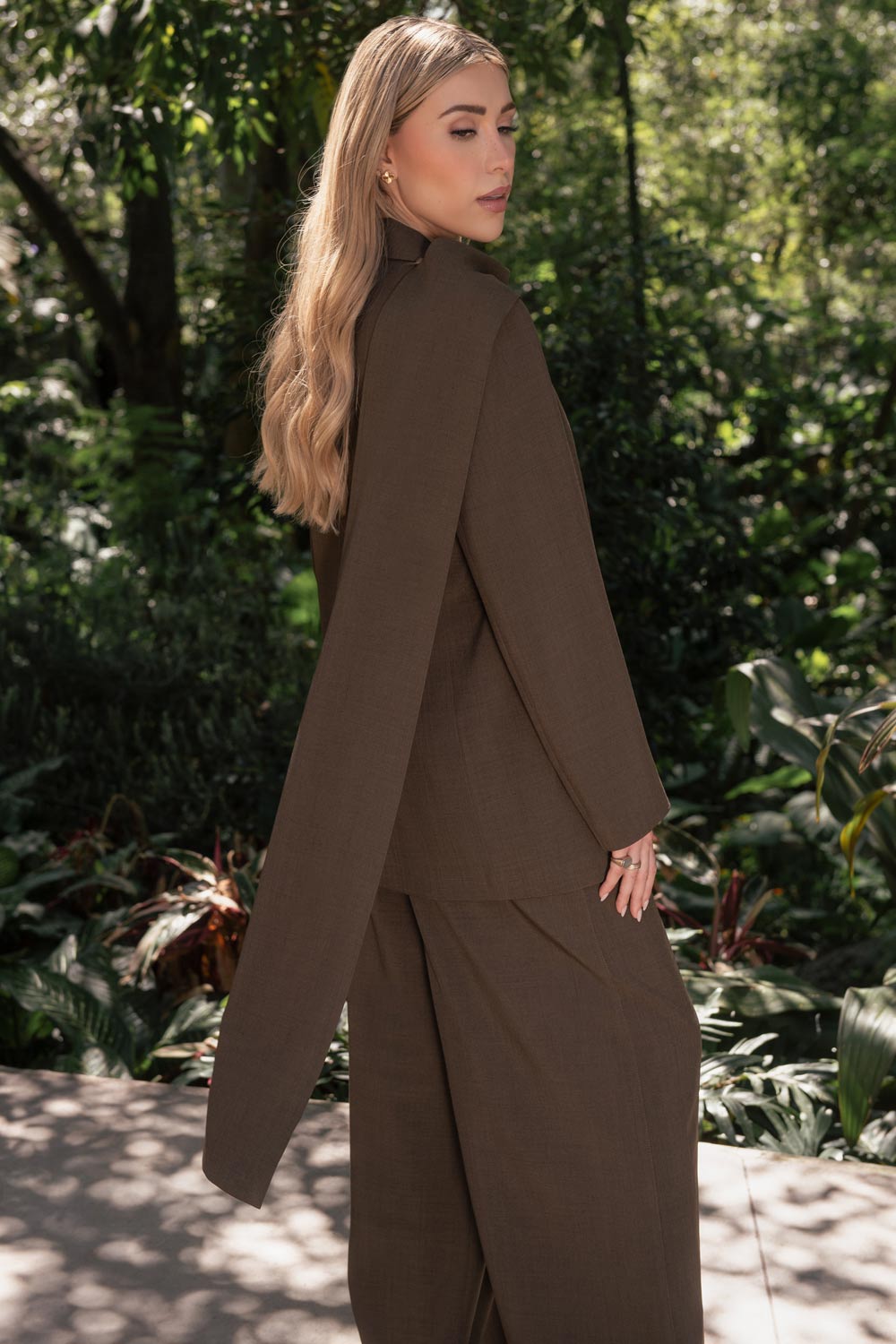 Pantalón de fit wide leg, cintura alta con pretina y trabillas, bolsillos delanteros y pinzas frontales. Cierre frontal con botón y cremallera oculta.